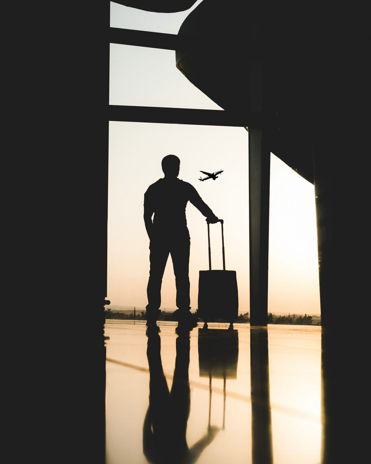 Ejecutivo con equipaje en aeropuerto al amanecer